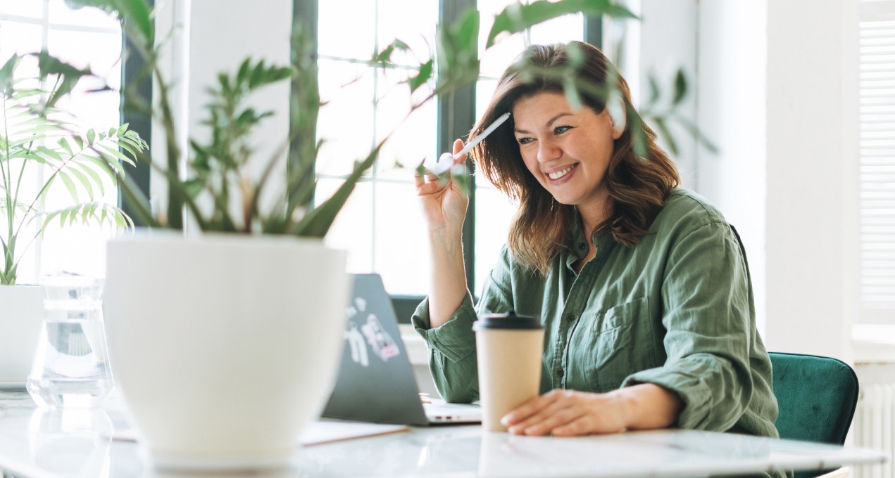 lady working on laptop smiling with lots of indoor plants